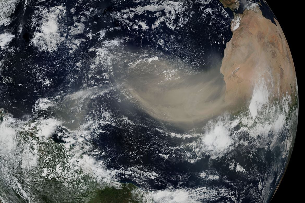 Satellite view of Earth showing the Atlantic Ocean, South America, Africa and a large dust plume crossing the ocean.